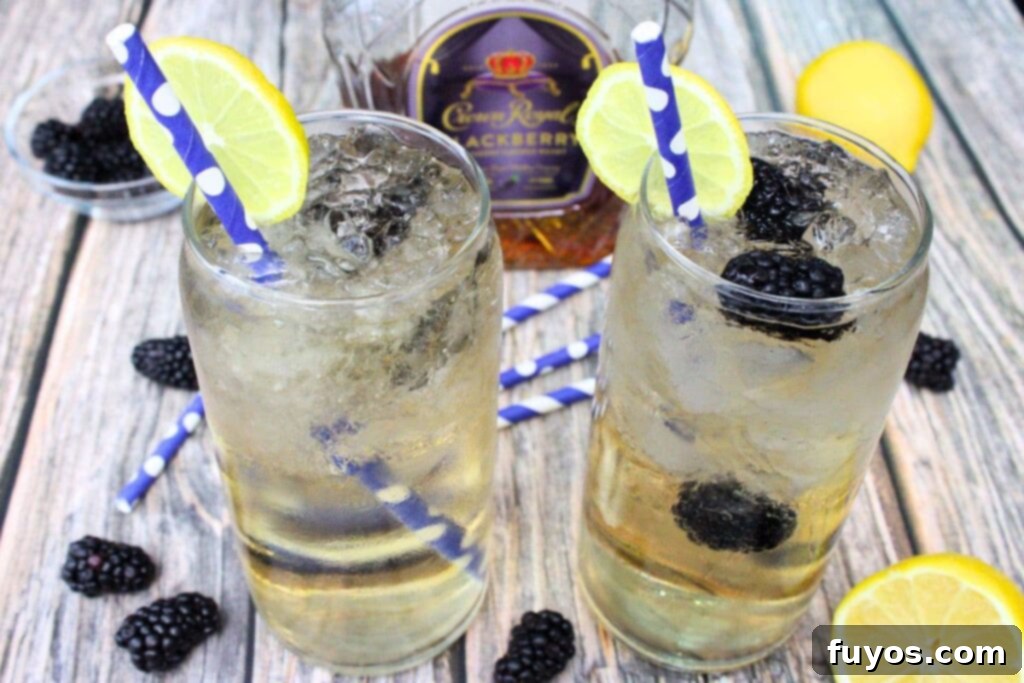 Two Crown Royal Blackberry and Sprite cocktails on a wooden table, with the Crown Royal bottle visible in the background.