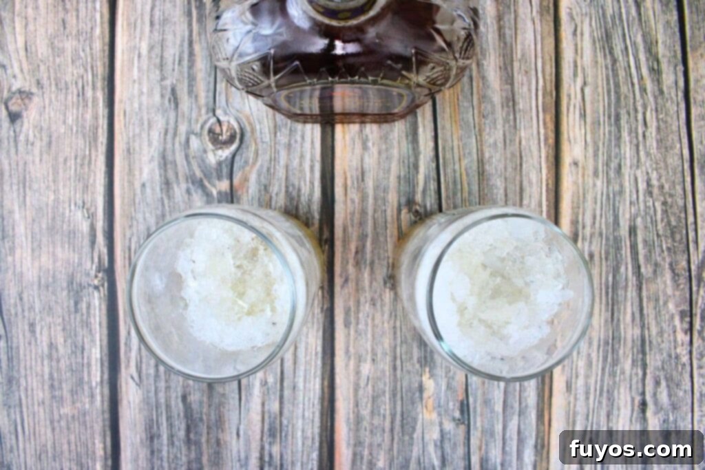 Pouring Crown Royal Blackberry whiskey into tall glasses filled with ice.