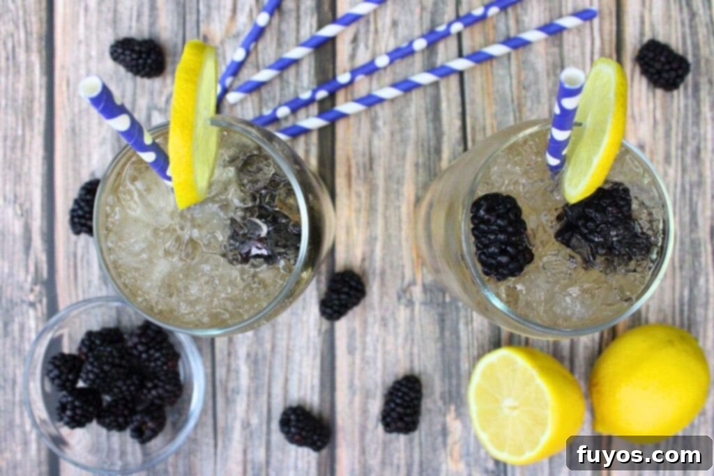 Overhead view of two finished Crown Royal Blackberry and Sprite drinks on a wooden table.
