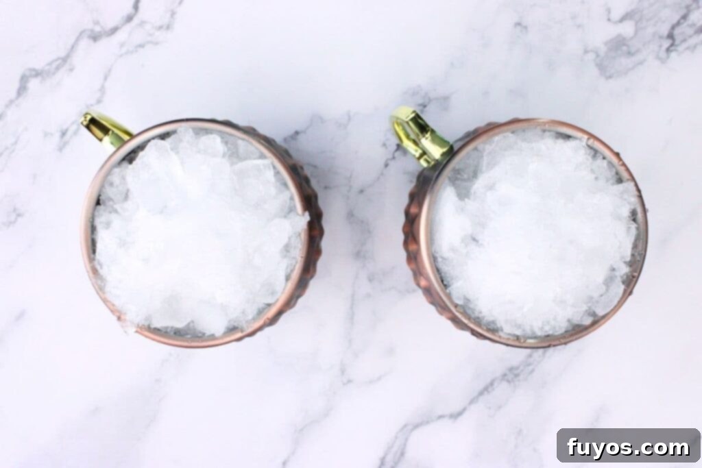 Filling a copper mug with crushed ice for a Blackberry Kentucky Mule cocktail.