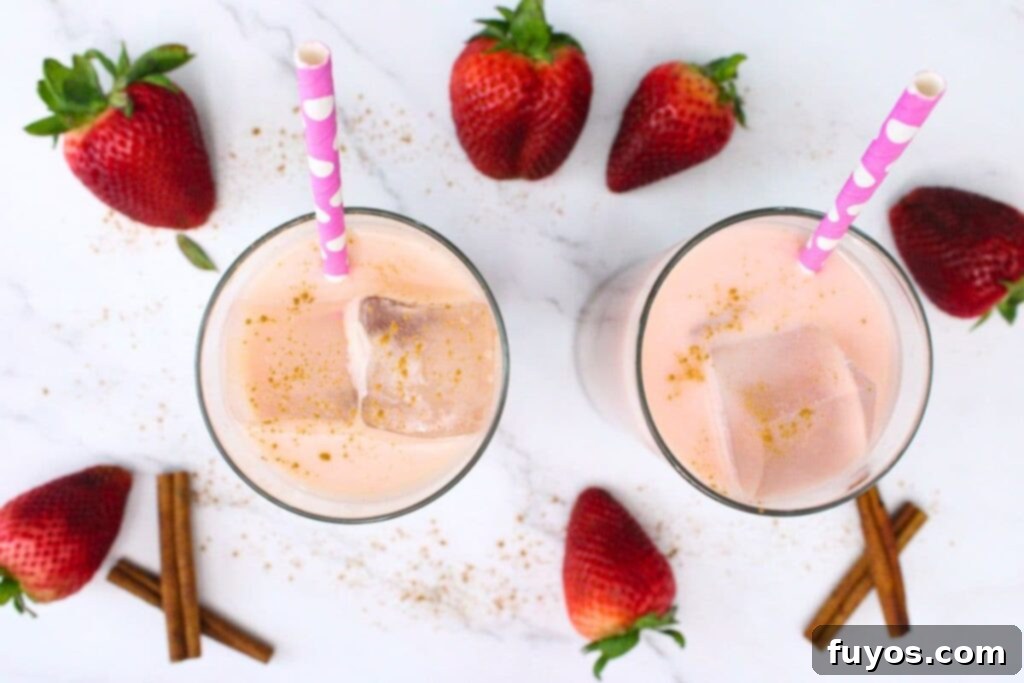 Dutch Bros Inspired Strawberry Horchata Chai 7 An inviting overhead shot of two glasses filled with delicious strawberry horchata chai, surrounded by fresh, ripe strawberries, ready to be served.