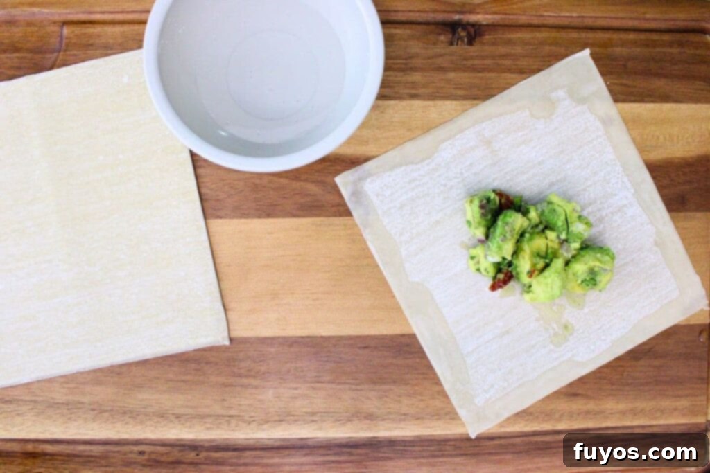 Air Fryer Copycat Cheesecake Factory Avocado Egg Rolls 8 run a wet finger along the edge of the egg roll wrapper to moisten and seal