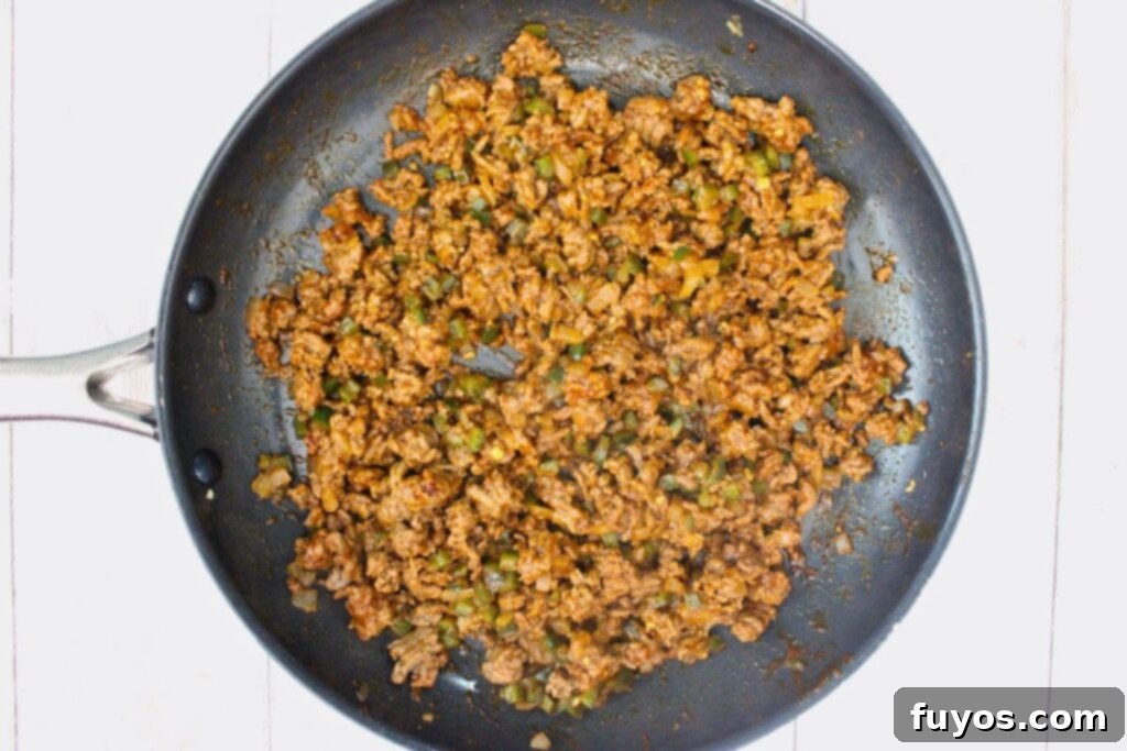 drain excess grease then add garlic and taco seasonings to the beef