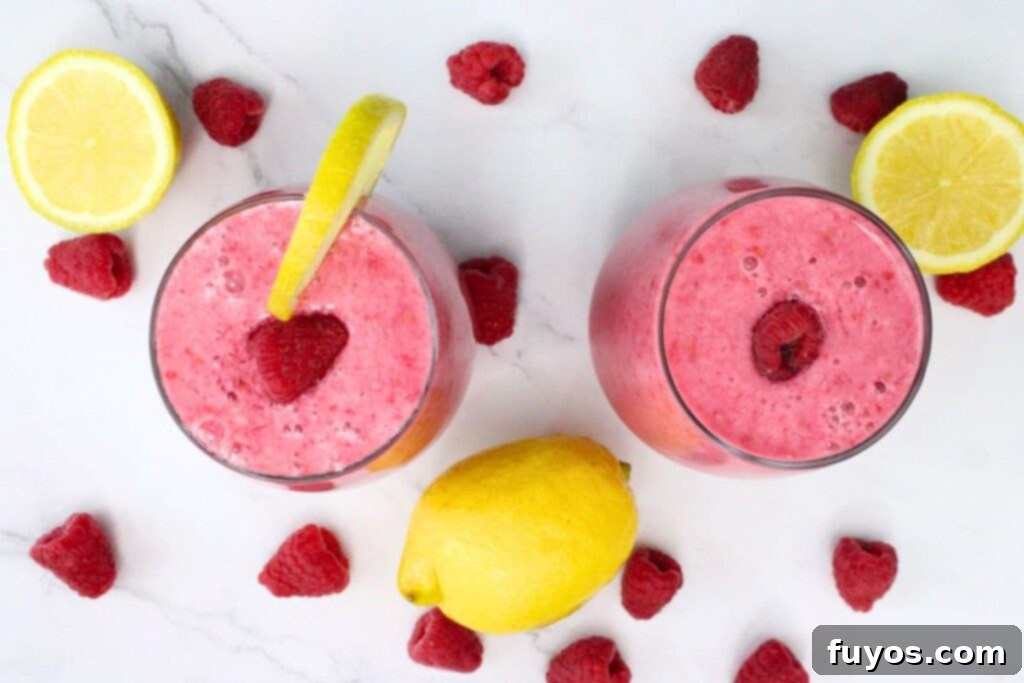 Beat the Heat with a Raspberry Lemonade Smoothie 7 overhead view of two raspberry lemonade smoothies surrounded by fresh fruit