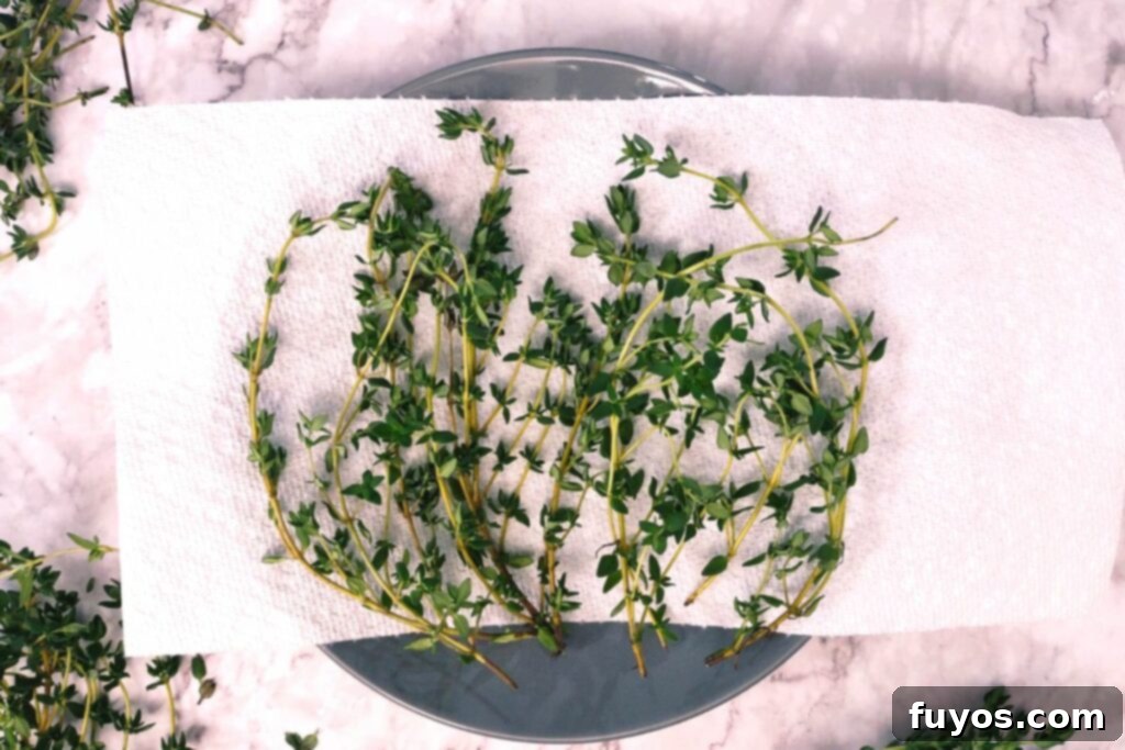 Effortless Microwave Thyme Drying 4 fresh thyme sprigs laid on a paper towel