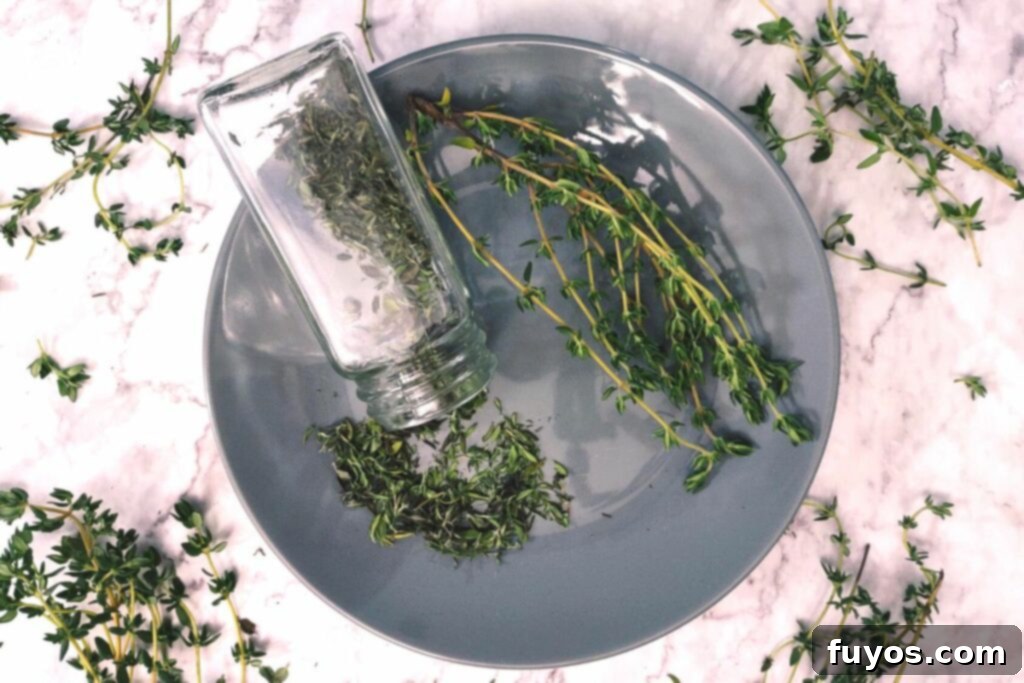 Effortless Microwave Thyme Drying 8 overhead shot of microwave dried thyme spilling out of glass jar with stems to the side