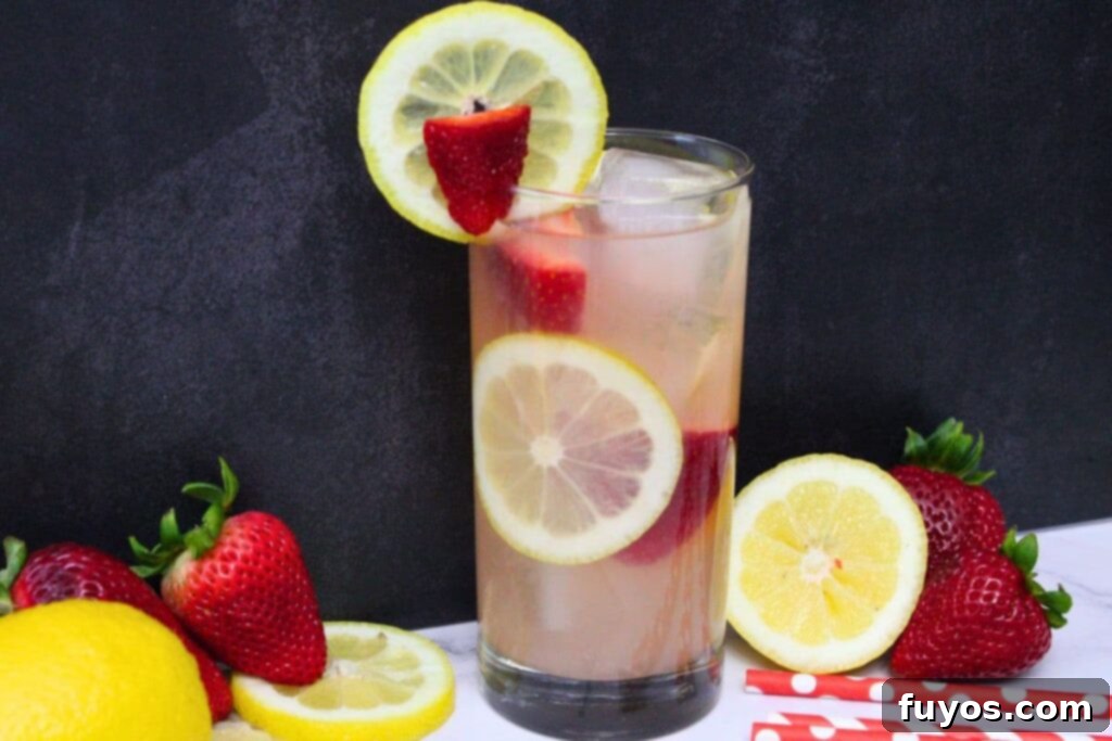 Easy Summer Strawberry Vodka Lemonade Recipe 9 strawberry vodka lemonade drink against a dark background surrounded by fresh fruit