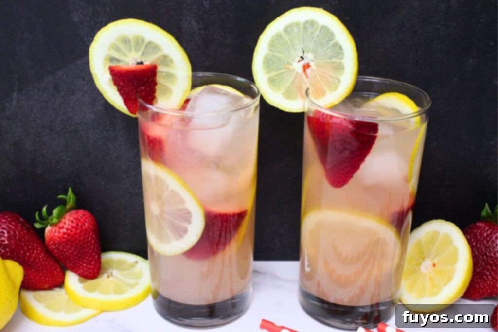 Easy Summer Strawberry Vodka Lemonade Recipe 3 two strawberry vodka lemonade cocktails with fresh fruit in the rim