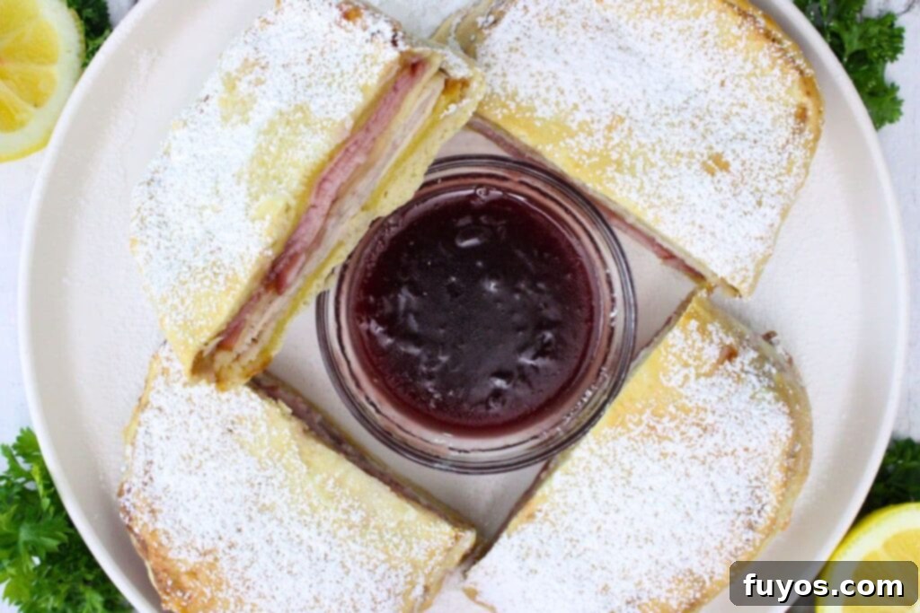 Air Fryer Monte Cristo A Taste of Disneyland 8 overhead view of two air fryer monte cristo sandwiches cut in half circling a bowl of raspberry jam