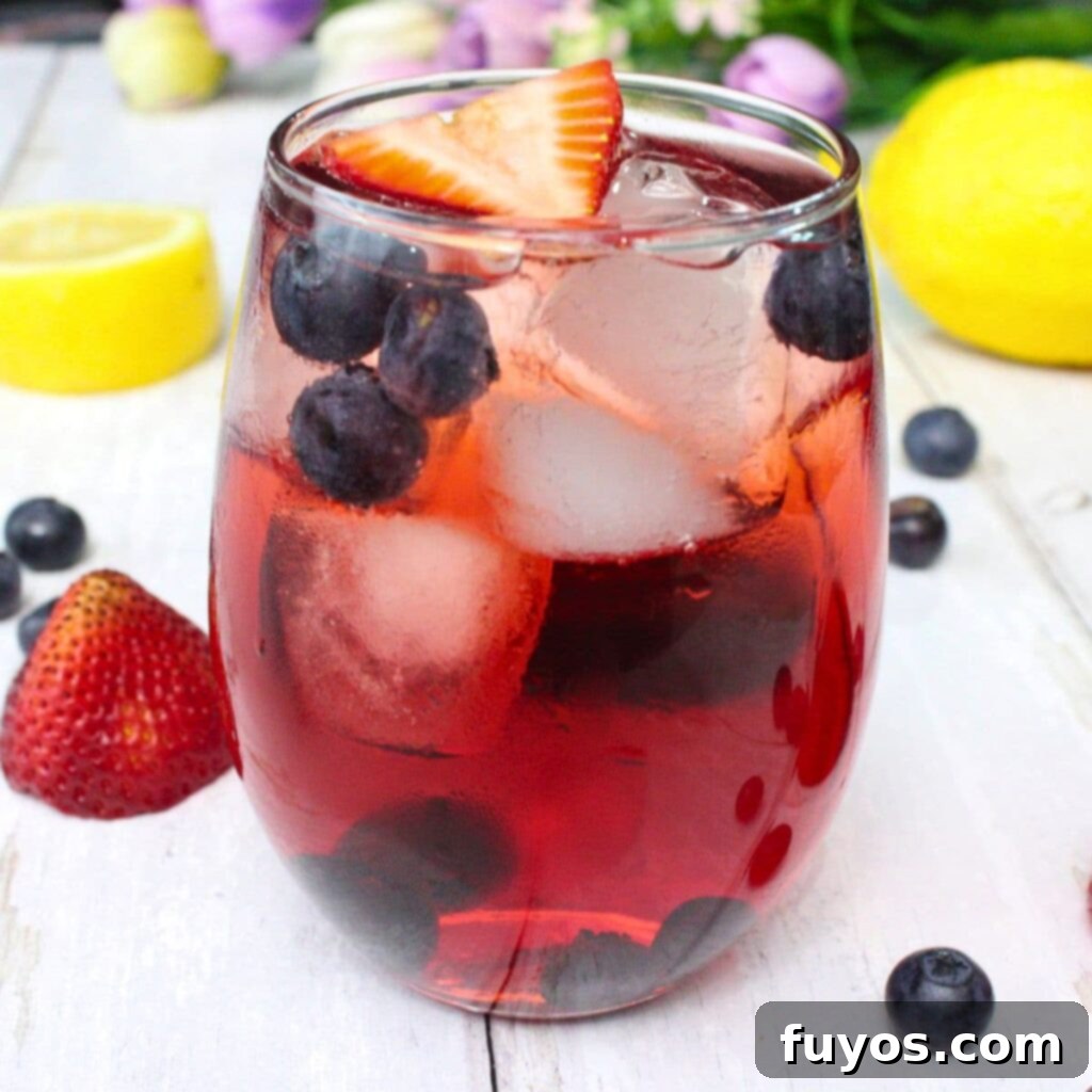 close up of a spring spritzer cocktail with lemon slices and berries, ready to be served
