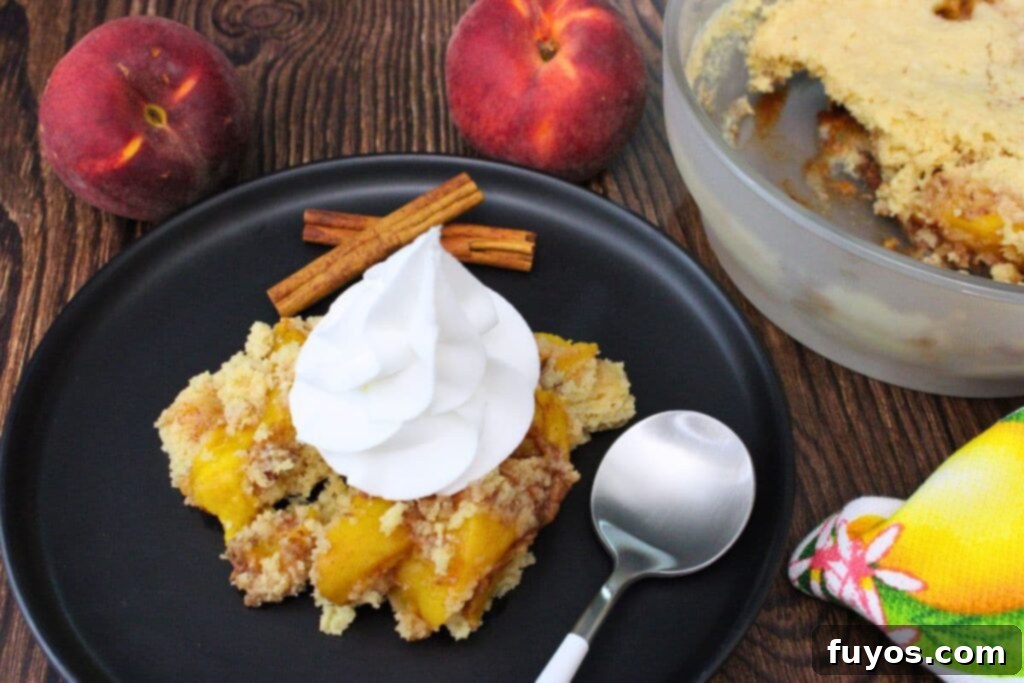 Microwave peach cobbler served on a plate, garnished with whipped cream for a delightful dessert.