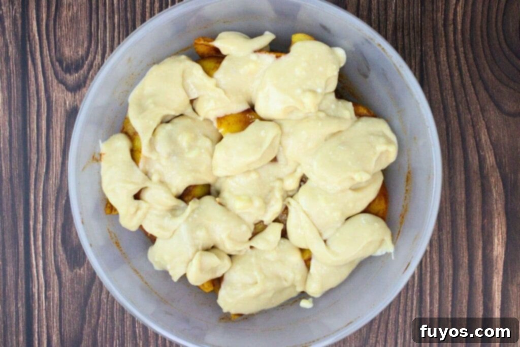 Step 3: Dollops of Bisquick batter are carefully dropped on top of the peaches in an even-ish layer.