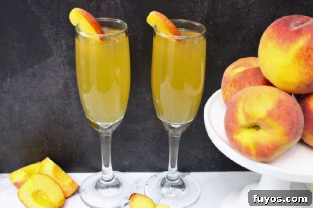 two crown peach mimosa cocktails next to a stand of peaches