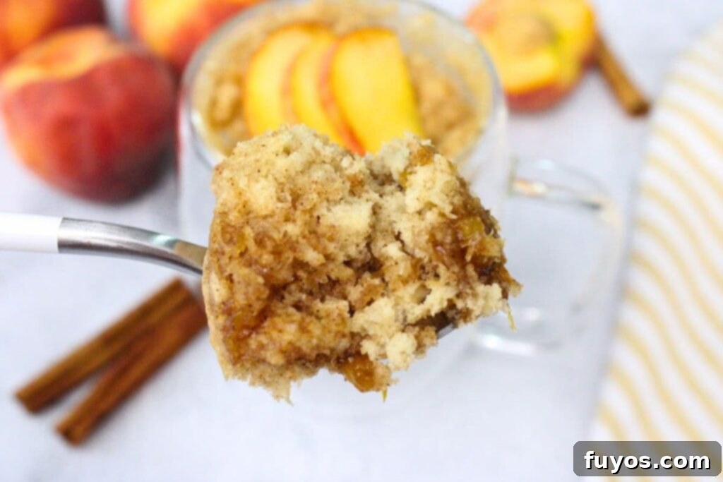 Peachy Microwave Dream in a Mug 3 holding up a spoonful of microwave peach mug cake
