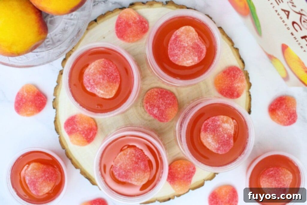 Effortless Crown Peach Jello Shots With Only Four Ingredients 9 overhead view of crown peach jello shots in cups spread across a platter and counter