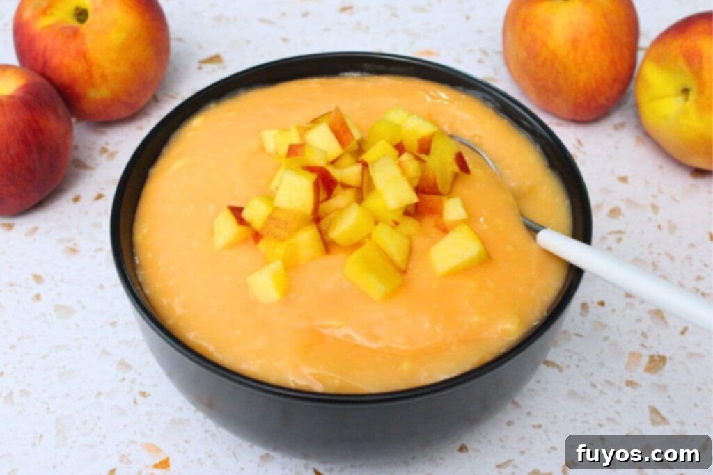 Effortless Peach Pudding in Minutes 10 black bowl filled with microwave peach pudding with a spoon in it