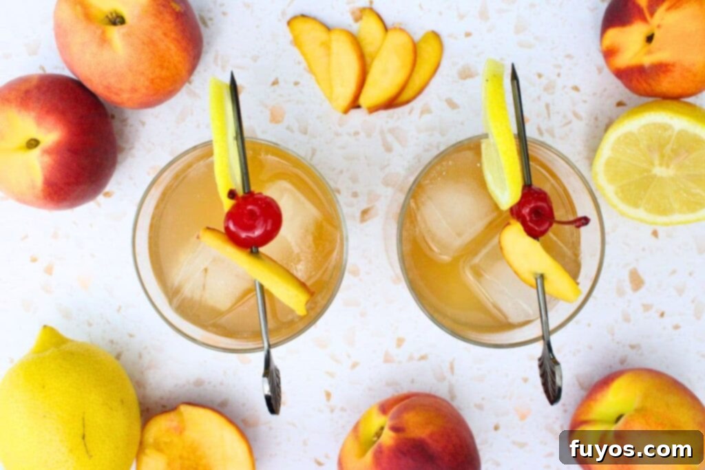overhead view of two crown peach whiskey sour drinks with a skewer of lemon, peach, and cherry