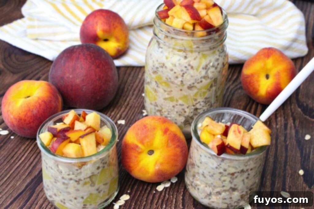One large mason jar and two smaller ones, all filled with creamy canned peach overnight oats, arranged on a rustic wooden surface.