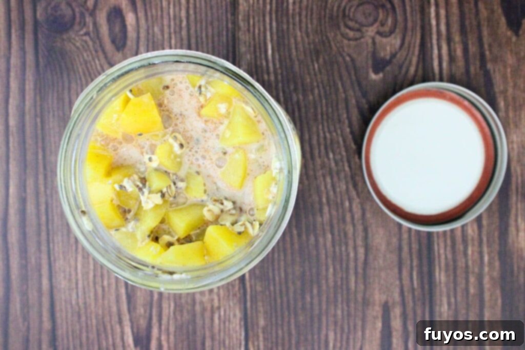 All the ingredients for canned peach overnight oats being added to a mason jar, ready to be mixed and refrigerated.