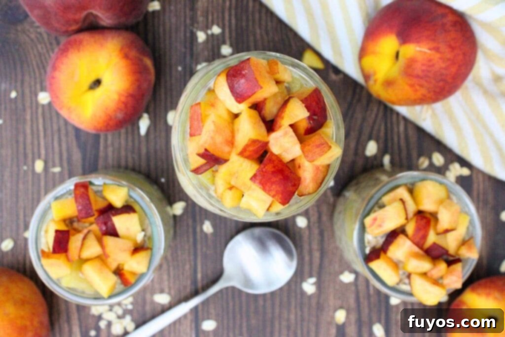 An overhead view of three jars of prepared canned peach overnight oats, garnished with fresh peach chunks and ready to serve.