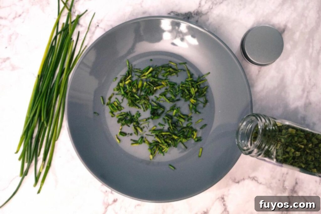 Microwave-dried chives on a plate, crumbled and ready to be transferred to a spice jar for storage.