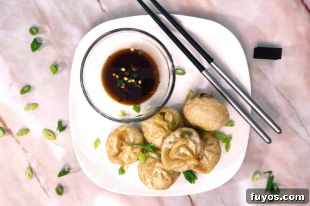 Crispy Bibigo Air Fryer Dumplings Pork or Chicken 7 air fryer bibigo dumplings on a plate with soy sauce and chopsticks