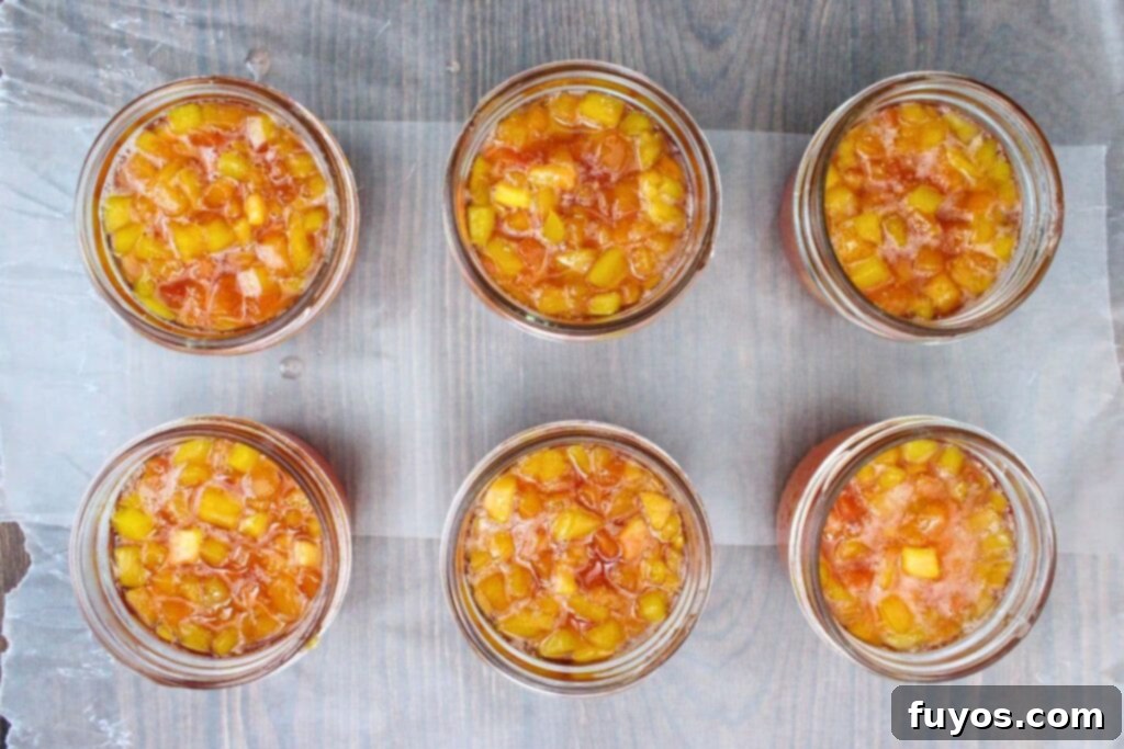 spoon peach jam into sterilized jars