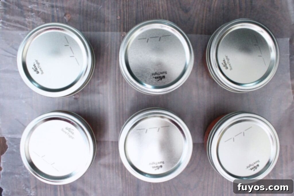 place lids and bands over peach jam jars