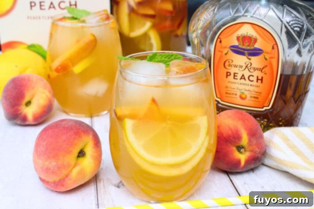 crown royal peach sangria cocktail next to the bottle and showcasing all the fresh fruit