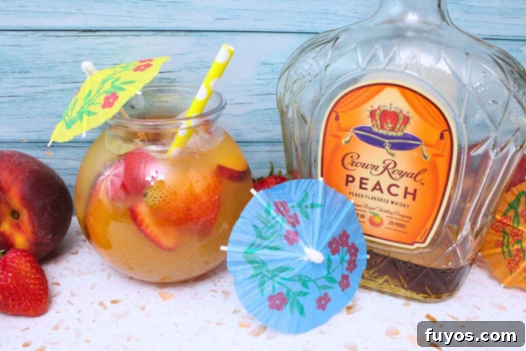 crown royal peach punch next to a blue cocktail umbrella and crown royal peach bottle