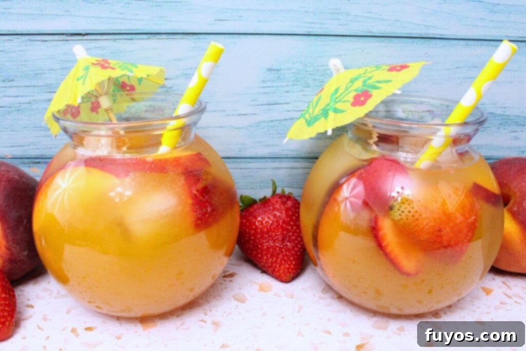 two tropical crown royal peach punch drinks against a blue wooden background