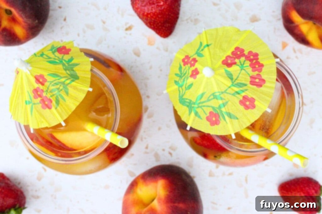overhead view of two crown royal peach punch drinks with yellow cocktail umbrellas
