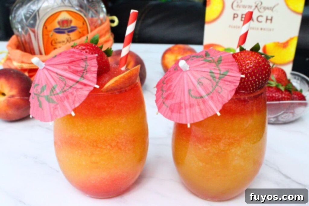 two crown royal peach daiquiri cocktails with tiny umbrellas and fresh fruit garnish