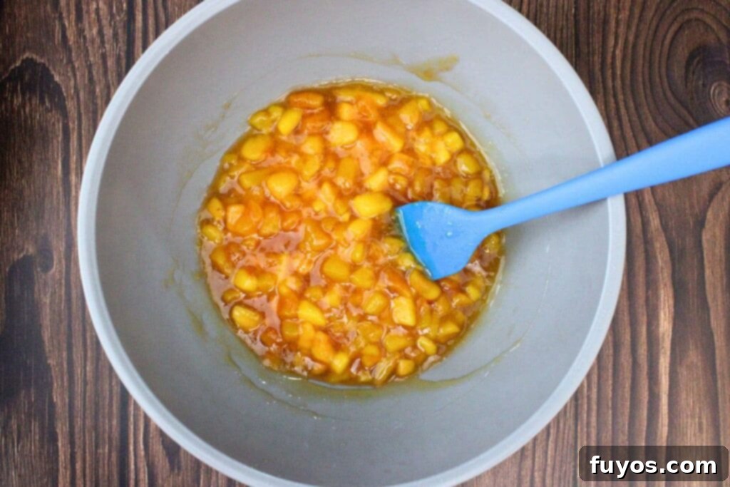Cooked peach mixture in a saucepan, thickened to a pie filling consistency.