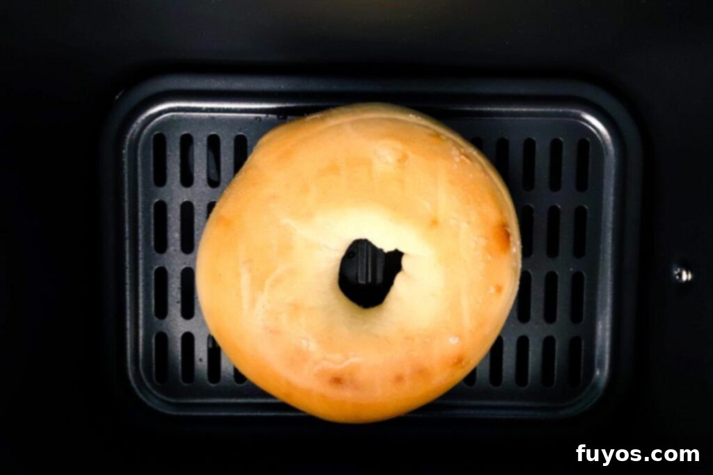 The Secret to Warm Fluffy Air Fryer Bagels 4 Placing a frozen bagel directly into the cold air fryer basket for defrosting.