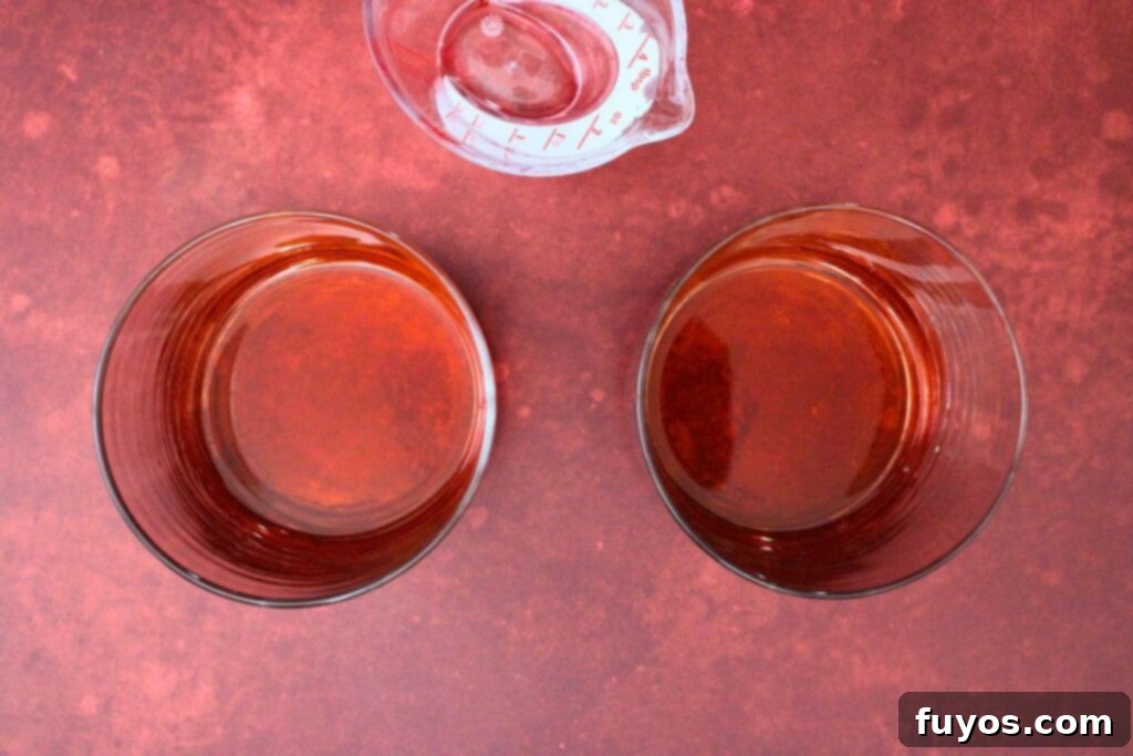 Blood Moon Rum Potion Zesty Halloween Brew 5 adding rum, grenadine, and Campari to a lowball glass for the blood moon cocktail