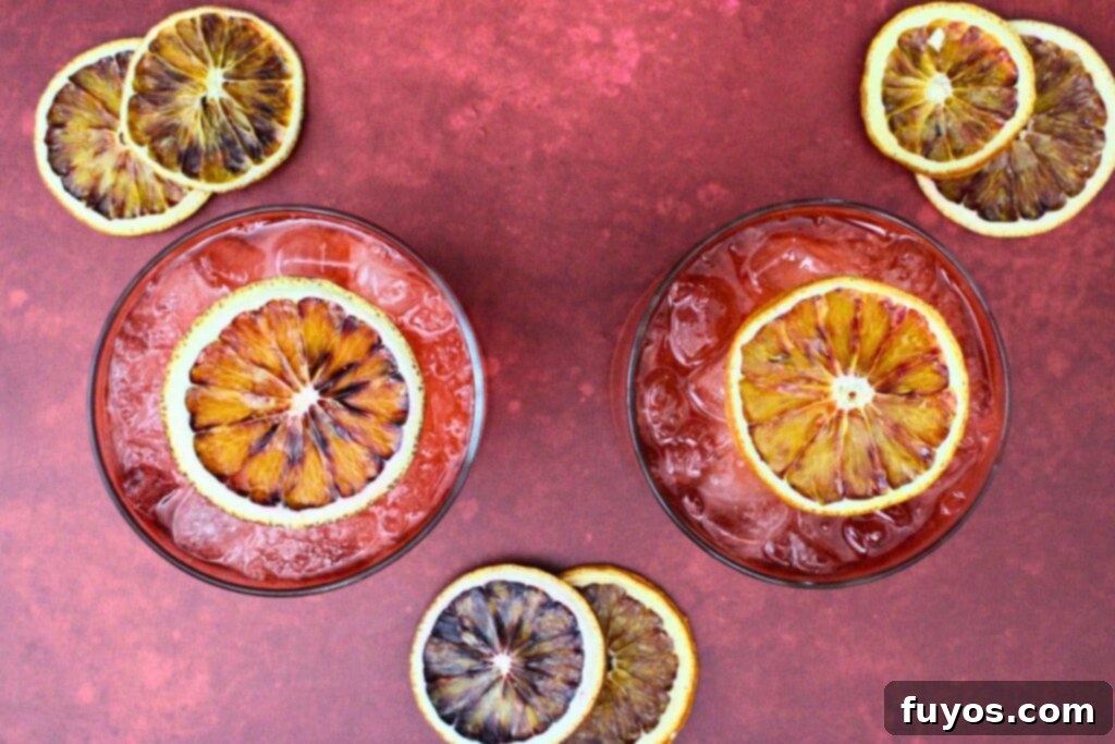 Blood Moon Rum Potion Zesty Halloween Brew 8 overhead view of two blood moon cocktails with dried blood orange slices, ready to be served
