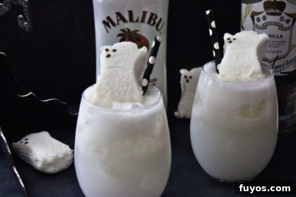 Two Drunk Ghost Cocktails in stemless wine glasses with ghost peep garnishes, positioned in front of bottles of coconut rum and vanilla vodka, highlighting the delicious spirits.