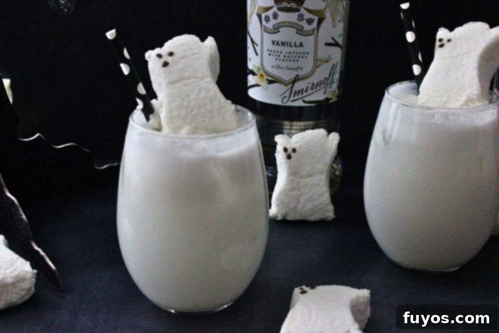 Two Drunk Ghost Cocktails in stemless wine glasses, standing proudly in front of a bottle of vanilla vodka, ready for a Halloween celebration.