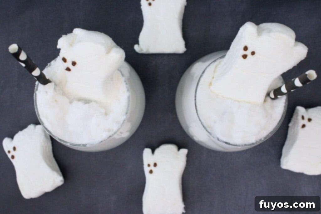 An overhead shot of two beautifully garnished Drunk Ghost Cocktails, each with a ghost peep marshmallow, ready to be enjoyed at a Halloween party.