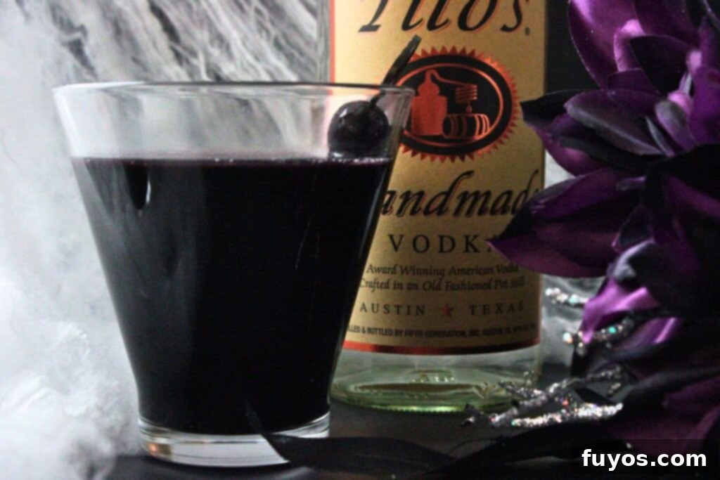 Black Magic Martini: Halloween's Darkest Spell 8 closeup side view of black martini drink in front of vodka bottle