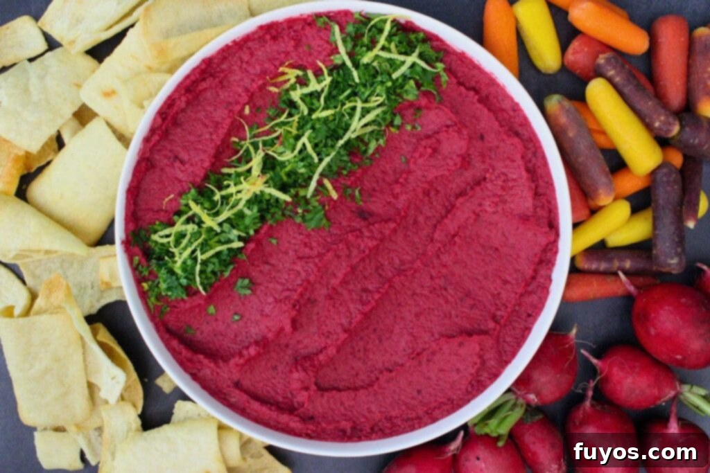 Air Fryer Roasted Beet Hummus 9 bowl of air fryer roasted beet hummus surrounded by pita chips and fresh vegetables