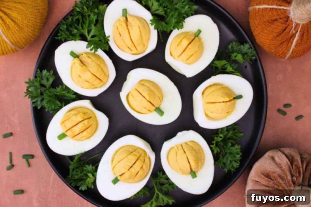 overhead view of pumpkin deviled eggs circling a black plate