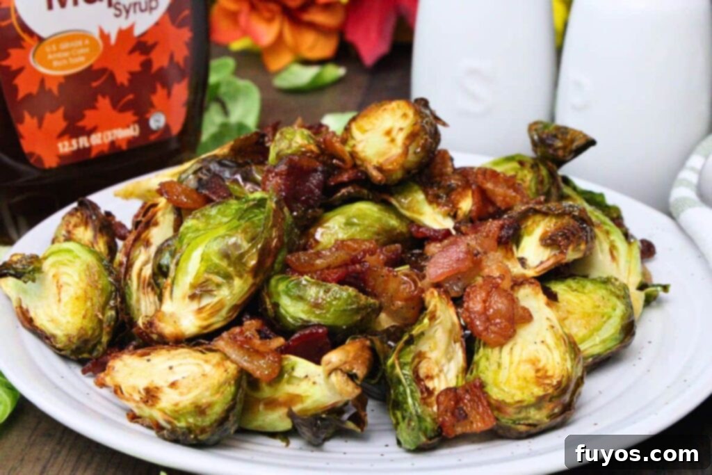 air fryer maple bacon brussel sprouts on a plate in front of syrup bottle and salt and pepper shakers