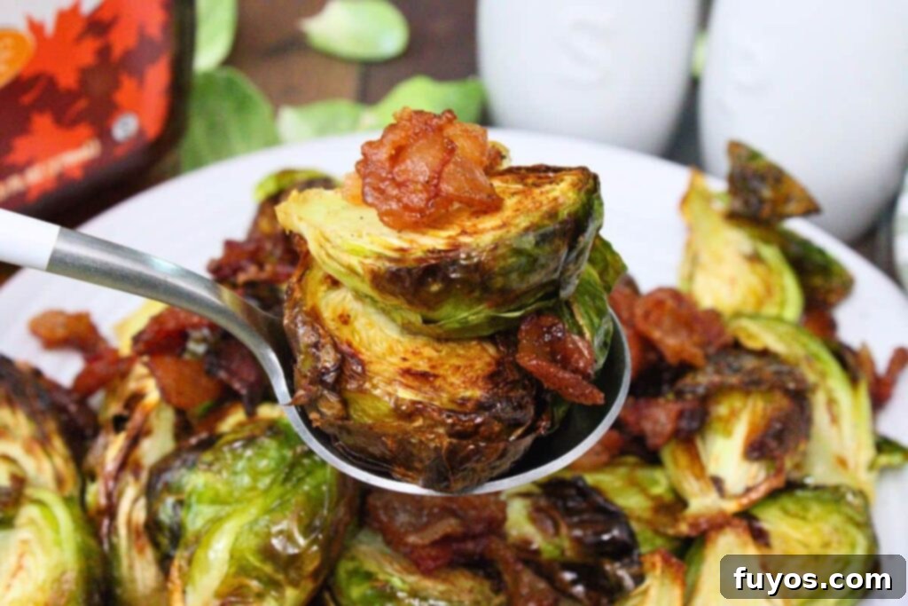 holding up a spoon of air fryer brussel sprouts with maple bacon