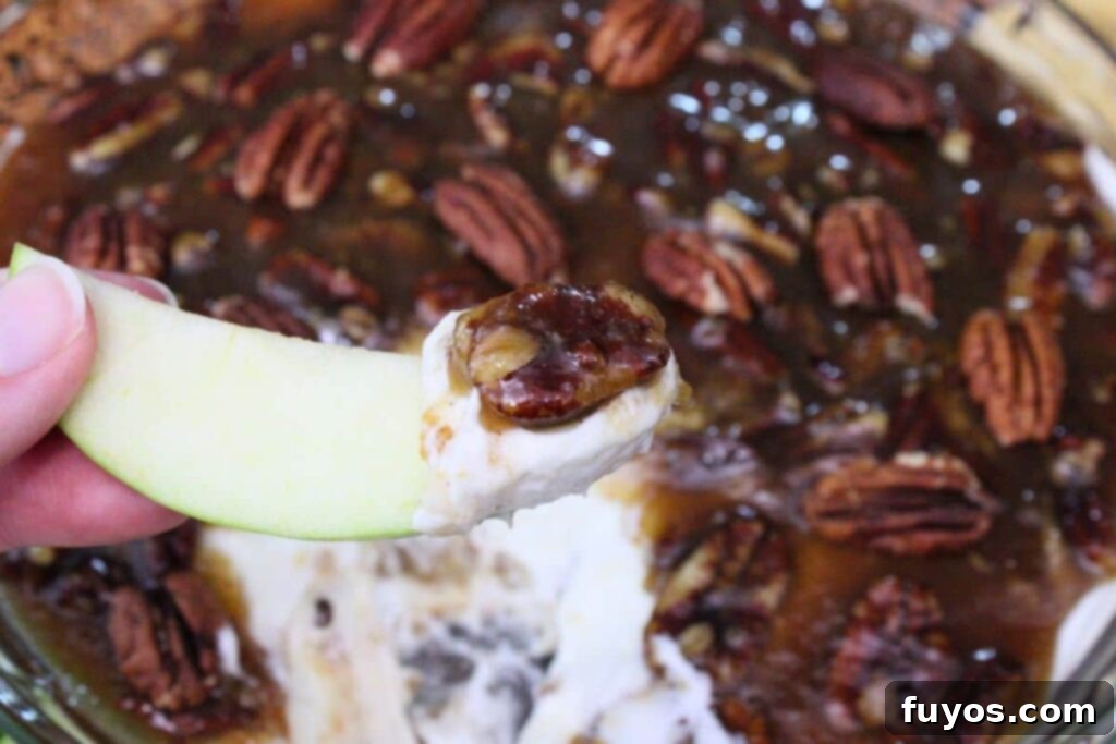holding up an apple slice dipped in pecan pie dip