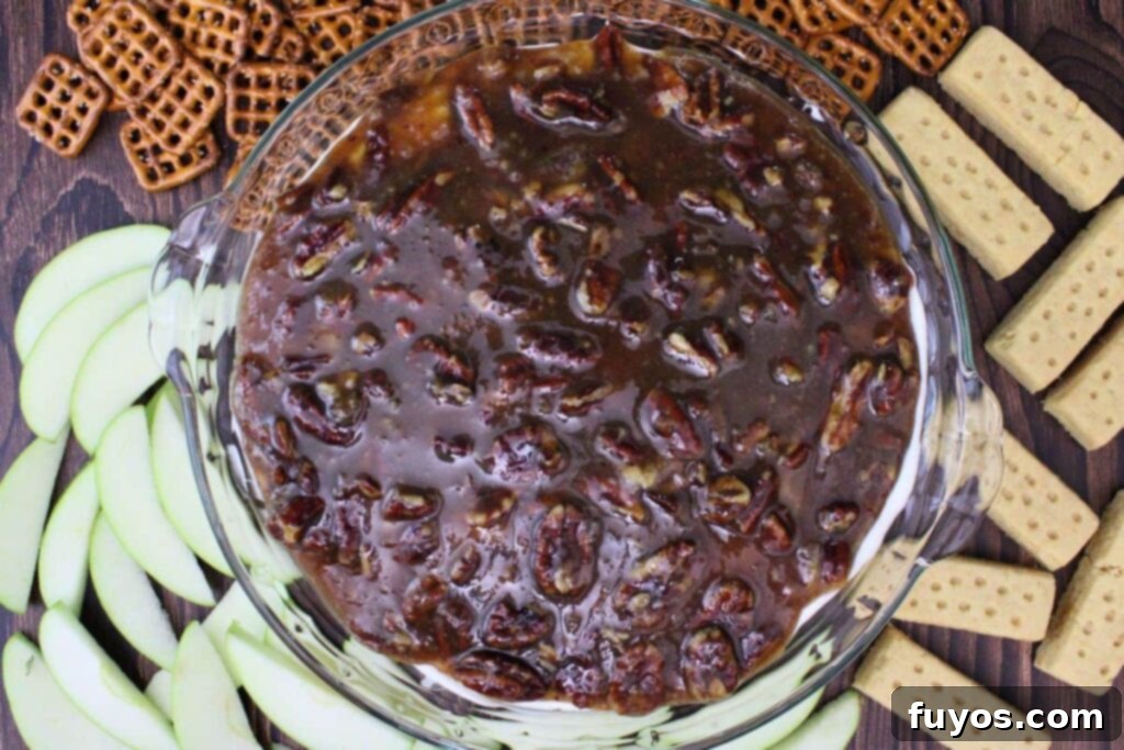 overhead view of pecan pie dip surrounded by apple, pretzels, and shortbread cookies