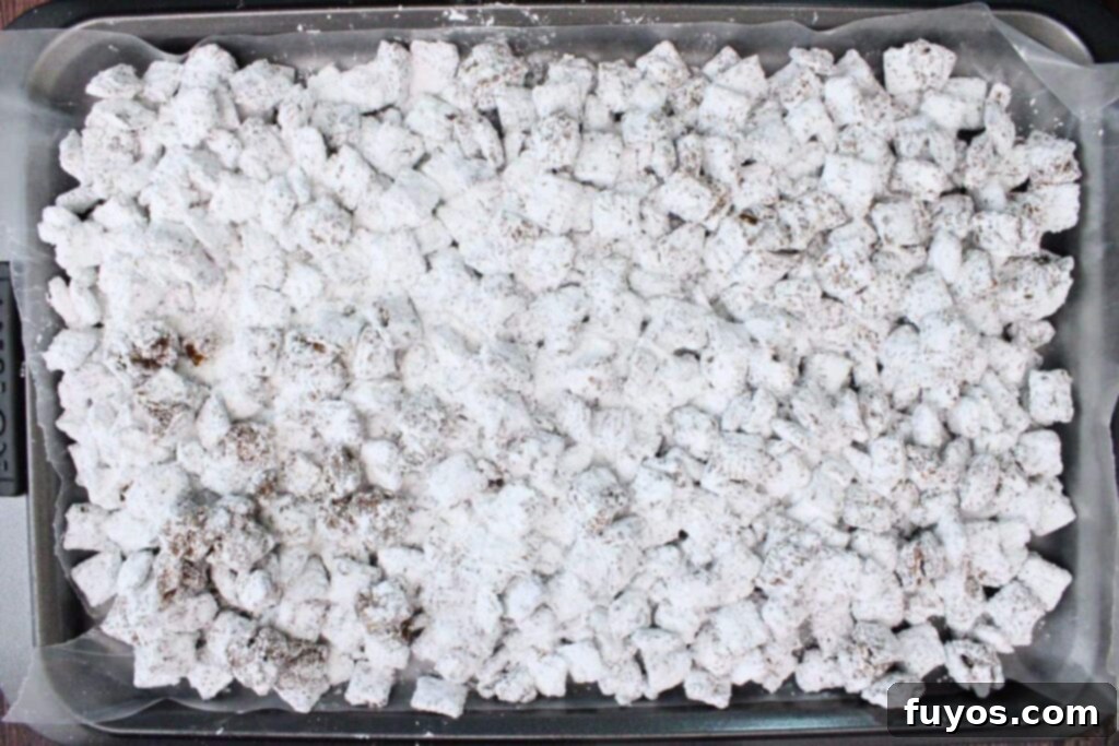 Easy No Bake Christmas Puppy Chow 10 spread finished coated cereal in a sheet pan