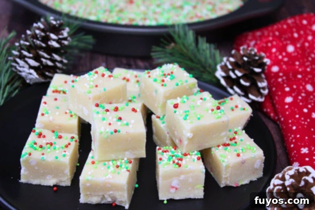 Easy Microwave Christmas Sugar Cookie Fudge Treat 3 Stacked sugar cookie fudge squares with holiday pine cones in background