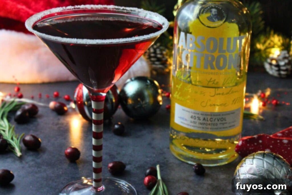 Santa Clausmopolitan Your Ultimate Holiday Drink 9 santa clausmopolitan cocktail next to vodka bottle in holiday setting with santa hat